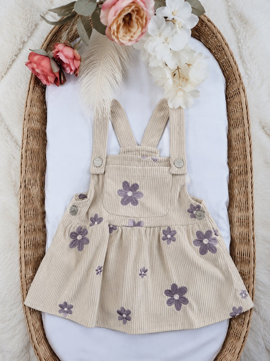 Cream corduroy pinafore dress with dusty purple embroidered daisies